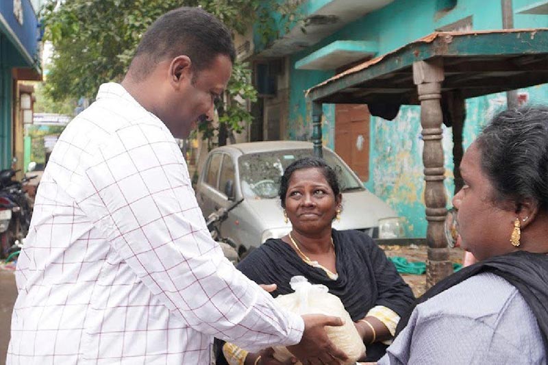 Distributing 5 kg rice bags to specially-abled res